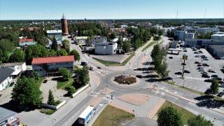 Ilmasta kuvattu näkymä Tehtaankadun liikenneympyrästä ja sen lähialueesta teineen ja rakennuksineen. Hieman kauempana, liikenneympyrästä erkaantuvan Torikadun keskellä seisoo Kokkolan vanha vesitorni.