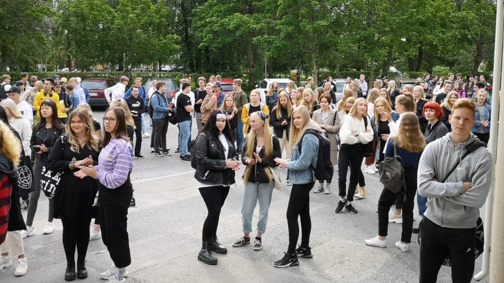 Uudet opiskelijat odottamassa ensimmäisen lukiopäivän alkamista koulun pihalla