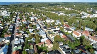 Ilmasta otettu kuva Neristanin yläpuolelta. Etualalla näkyy Kokkolan vanhaa kaupunkia katuineen, pihoineen ja rakennuksineen. Hieman kauempana näkyy Urheilutalo ja sen takana vesitorni. Kaukana horisontissa siintää meri.