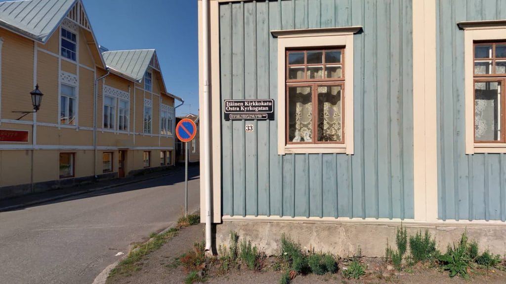Sinisen talon julkisivu Vanhakaupunki Neristanissa. Talon seinässä on osoitenimi- ja numerokyltti. Vasemmalla näkyy keltaisen talon julkisivua.
