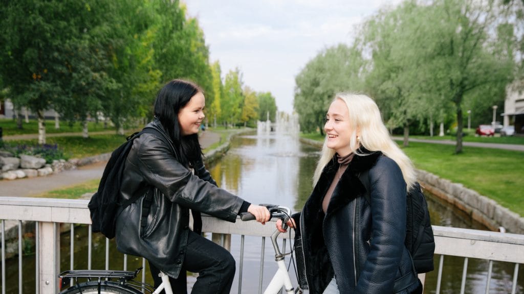 Kaksi tyttöä nauraa, taustalla Sunti ja suihkulähde