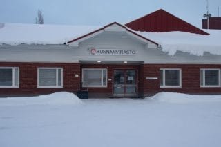 Punatiilinen rakennus, jossa yläosa valkoista laudoitusta. Keskellä rakennuksen sisäänkäynti ja sen yläpuolella kyltti Kunnanvirasto.