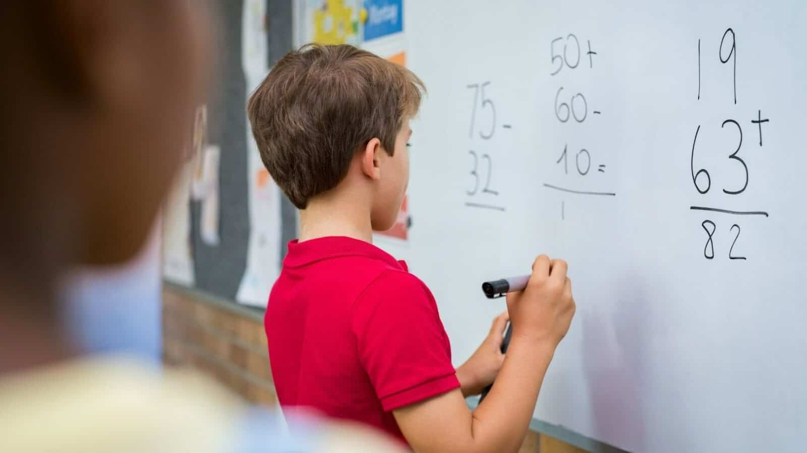 Oppilas tekee matematiikan tehtävää luokassa taululle